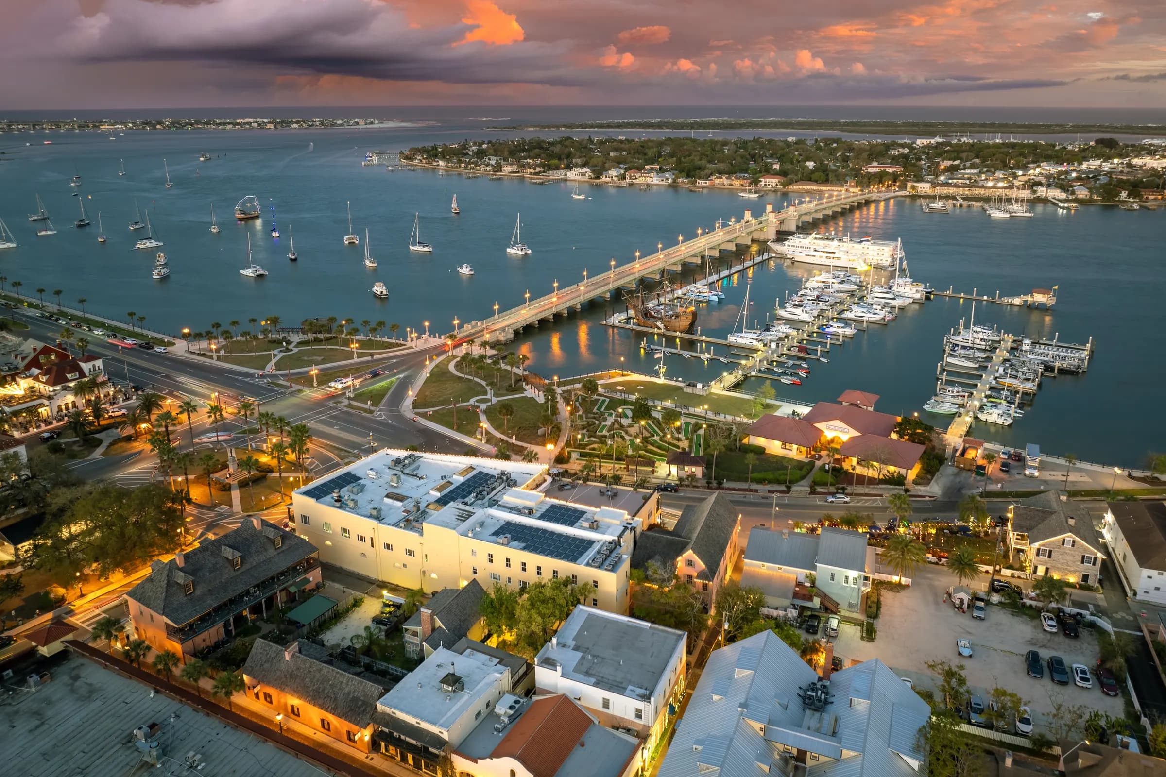 Aerial view of downtown St. Augustine at dusk, with the Bridge of Lions, the marina and Anastasia Island across the Matanzas River