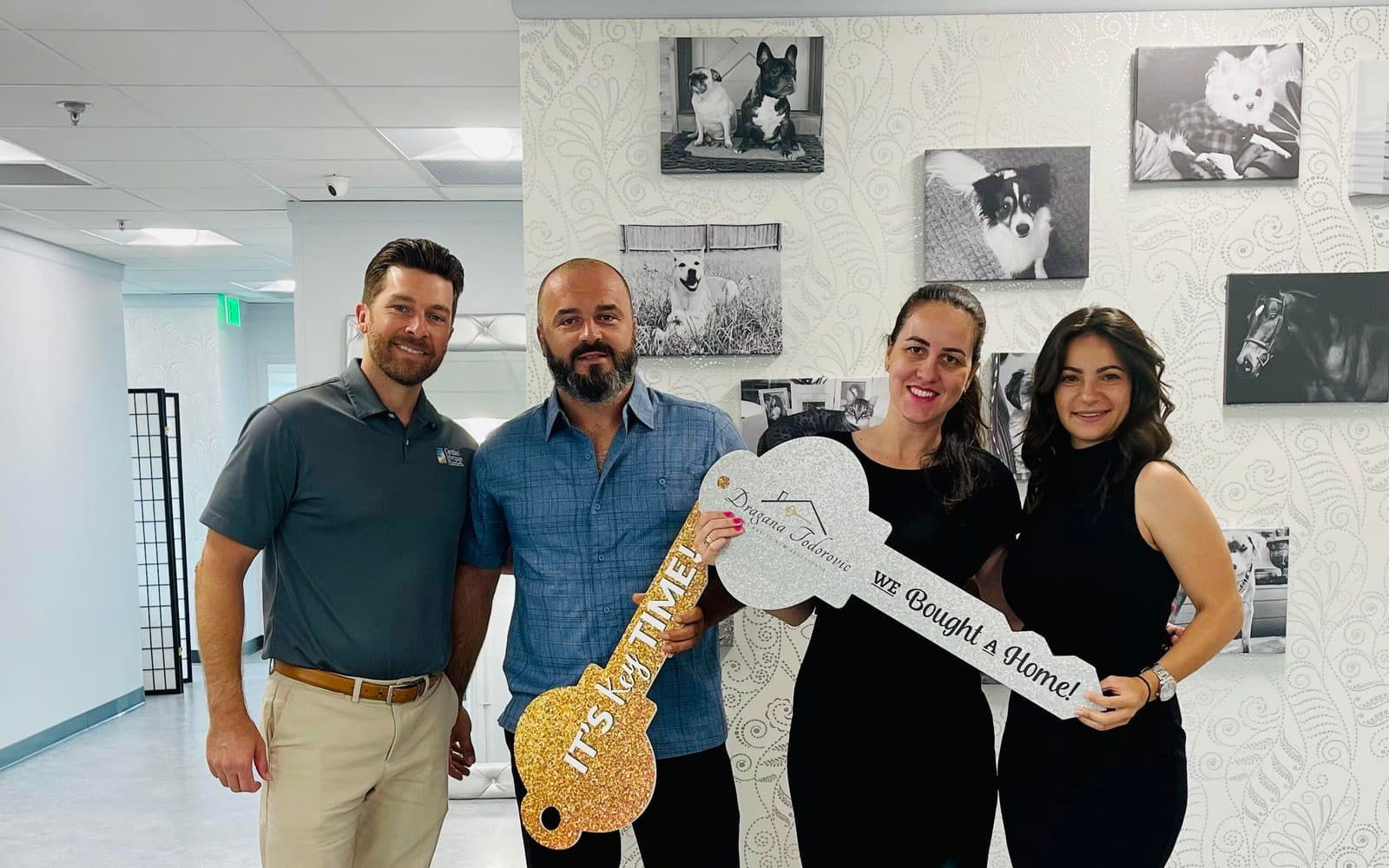 Clients celebrating their home purchase, holding a Dragana Todorović 'We Bought a Home' key