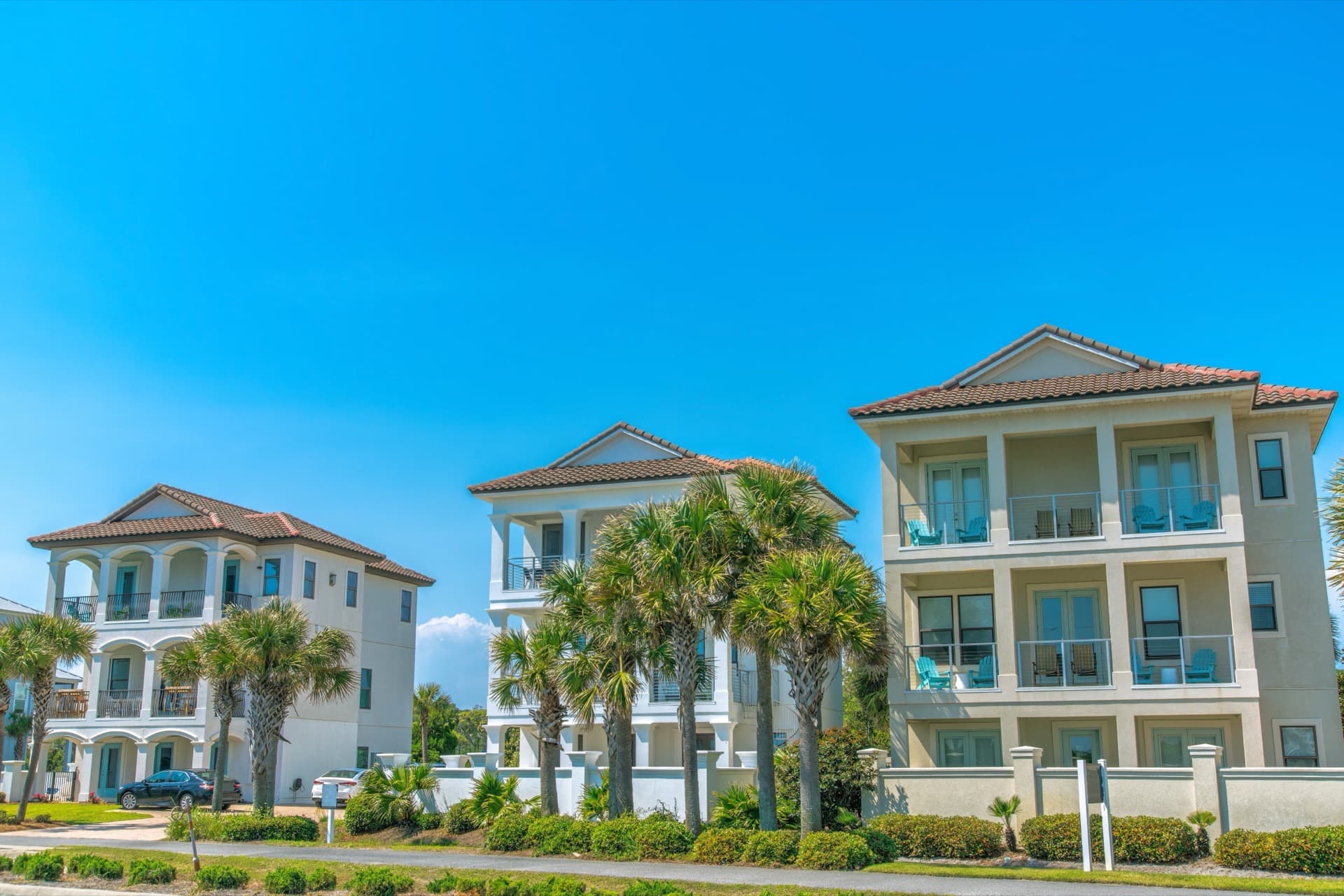 Three Florida homes with landscaped yards in a residential neighborhood