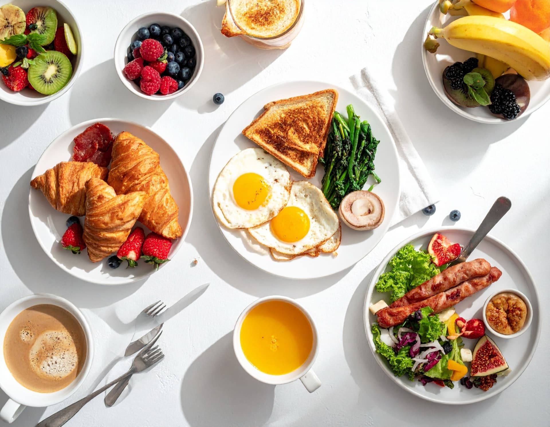 An overhead spread of brunch dishes — eggs benedict, pancakes, fresh fruit, and coffee — at a New Smyrna Beach restaurant