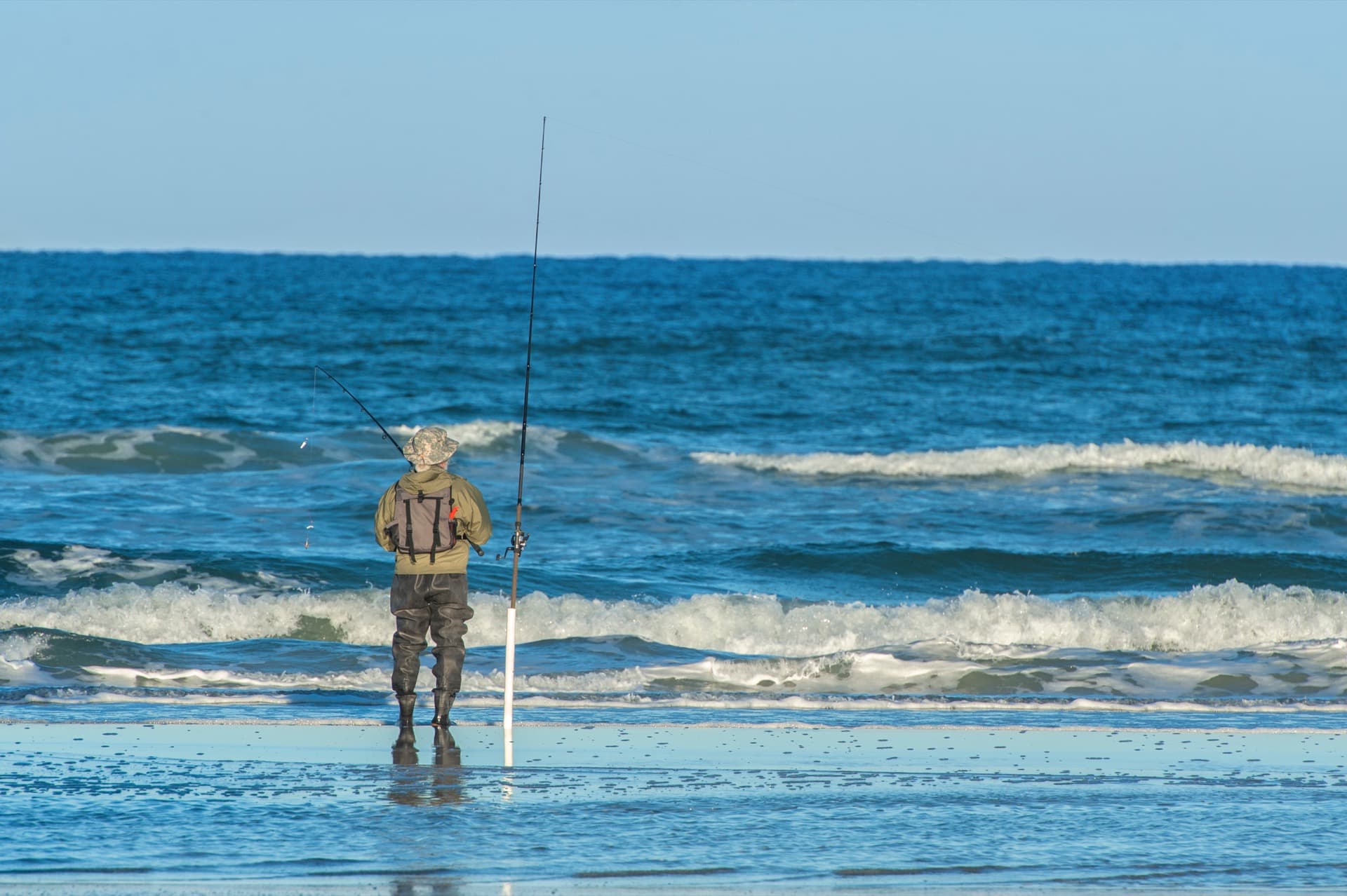 A fisherman casting off the New Smyrna Beach coast at golden hour