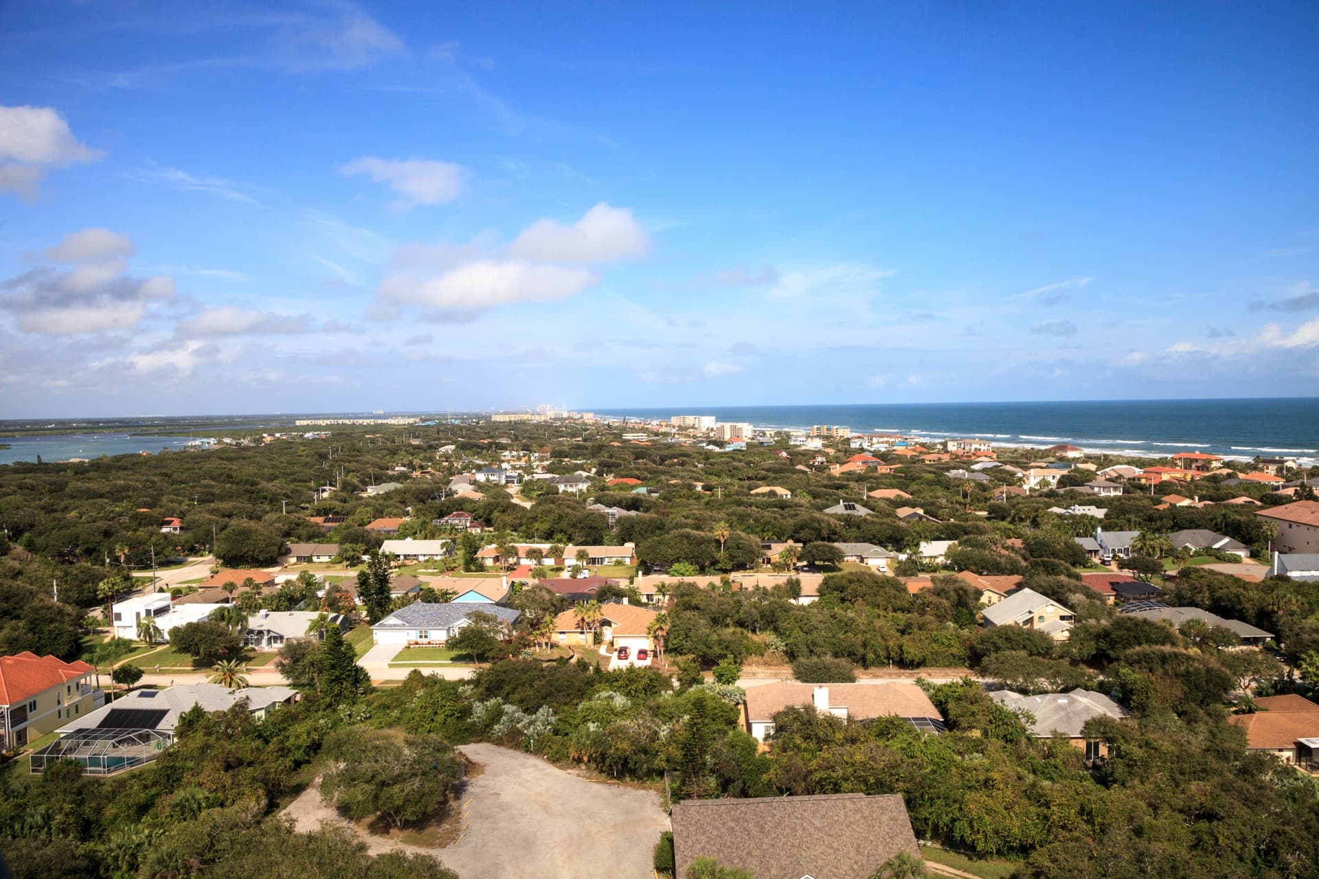 Aerial view of New Smyrna Beach residential neighborhoods stretching toward the Atlantic coastline and inlet
