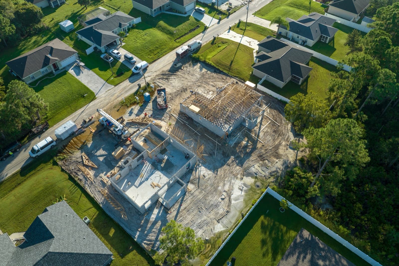 Aerial view of a new home under construction with exposed wooden roof framing in New Smyrna Beach, Florida