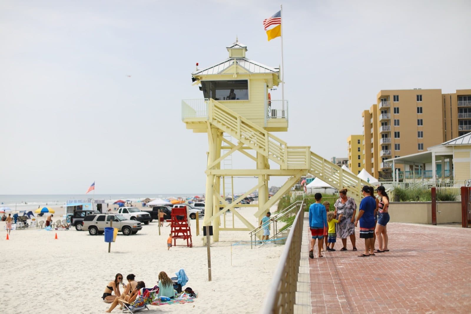 Beachgoers enjoying the sand near oceanfront condominiums in New Smyrna Beach