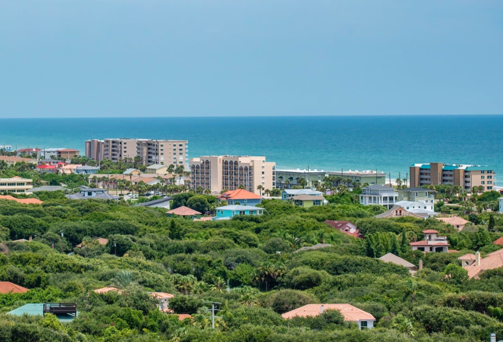 Oceanfront condo building in New Smyrna Beach with palm trees and beachfront access