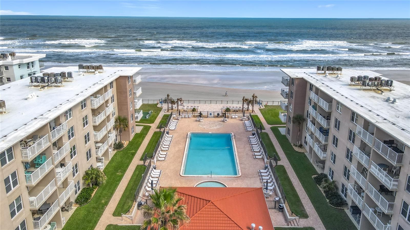 Aerial view of Sea Coast Gardens condominiums with pool and Atlantic Ocean in New Smyrna Beach, Florida