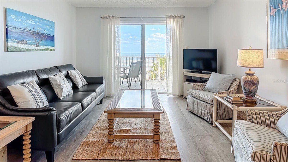 Updated living room in a Sea Coast Gardens condo unit with ocean-view balcony