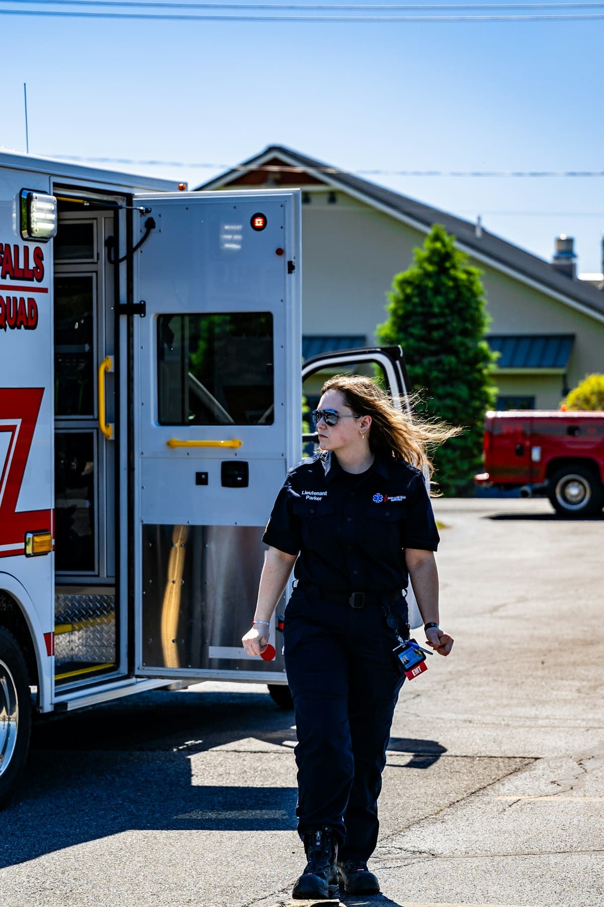 EMT walking beside an open ambulance on a sunny day