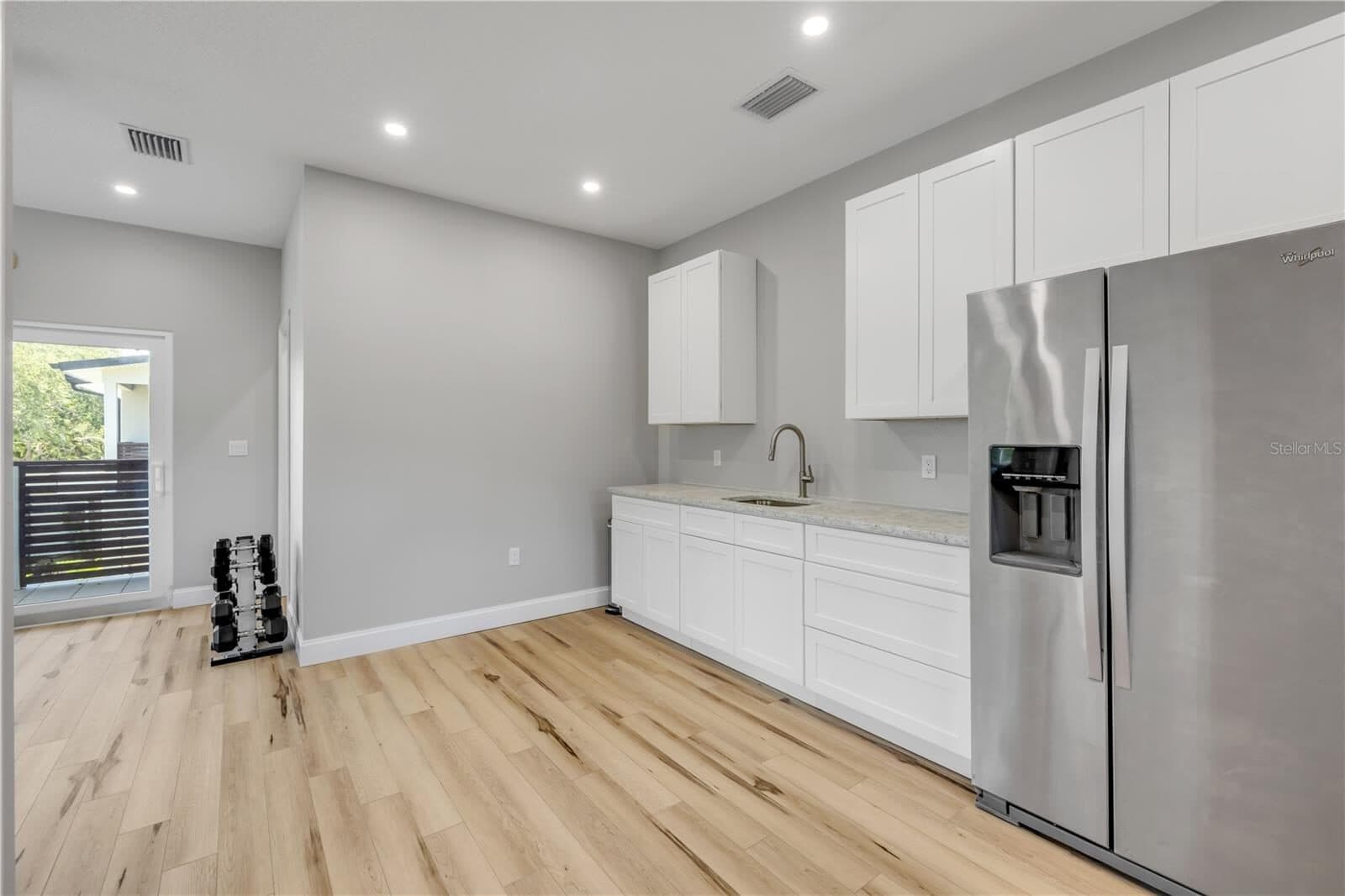 The guest apartment kitchenette, with a full-size refrigerator, sink and upper cabinetry