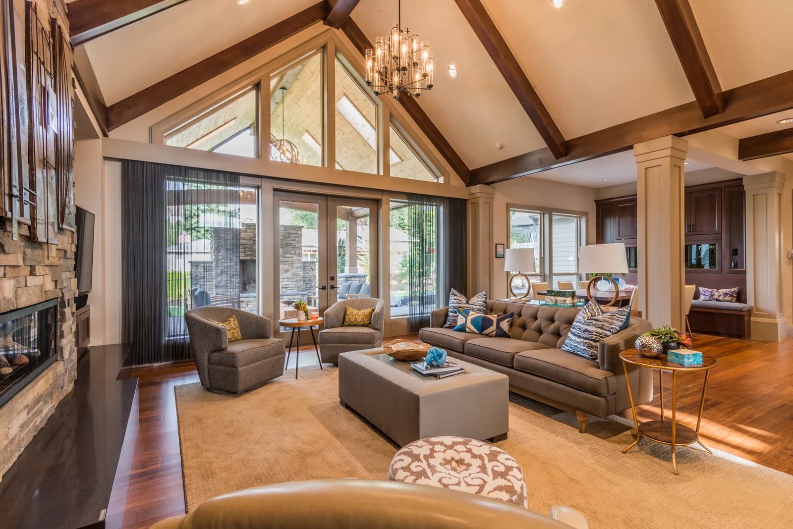 Furnished living room with sofa, armchairs, ottoman, rug, lamps and a chandelier